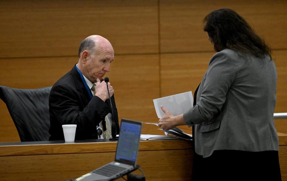 Dr. Russell Vega, Chief Medical Examiner for the 12 District, looks through autopsy photographs on the third day of Ashley Benefield’s trial for the second-degree murder of her husband, Doug Benefield, in 2020 at the Manatee County Judicial Center, July 25, 2024.