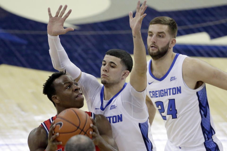 St. John's Rasheem Dunn, left, is defended by Creighton's Marcus Zegarowski, center, and Mitch Ballock (24) during the first half of an NCAA college basketball game in Omaha, Neb., Saturday, Feb. 8, 2020. (AP Photo/Nati Harnik)