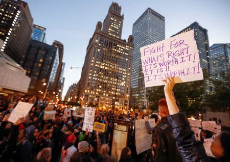 A protester holds a sign during a protest against Republican president-elect Donald Trump outside Trump International Hotel and Tower in Chicago, Illinois. REUTERS/Kamil Krzacznski