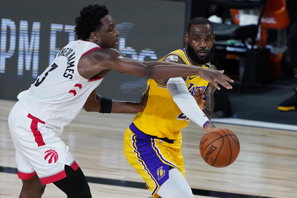 Los Angeles Lakers' LeBron James passes around Toronto Raptors' OG Anunoby (3) during the second half of an NBA basketball game Saturday, Aug. 1, 2020, in Lake Buena Vista, Fla. (AP Photo/Ashley Landis, Pool)