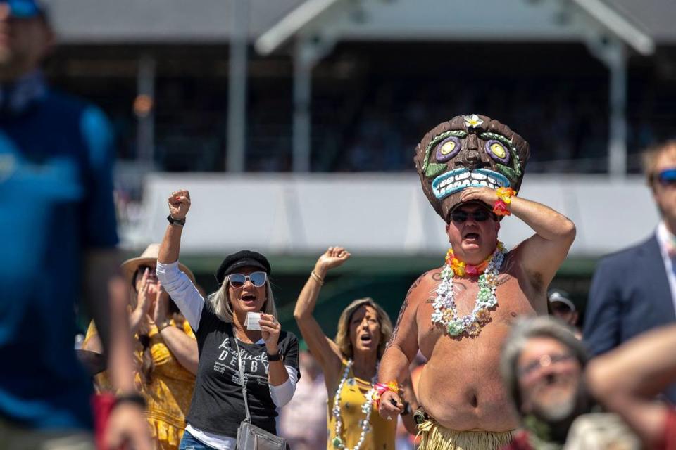 Lewis Grant, of Louisville, and wearing a tiki costume, cheered during the seventh race.