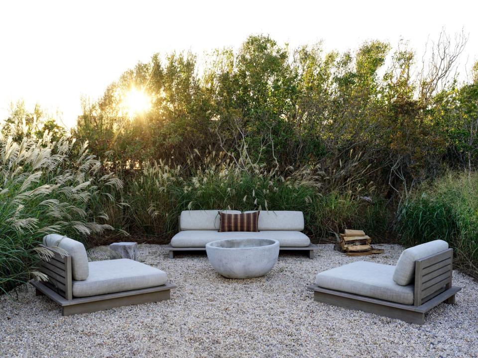 “In the summer we spend most of our time up on what we call the bluff, a little outdoor seating area that looks over the ocean,” says Rice. Much-used chaises and a sofa from RH’s Maldives collection sit around their second fire pit.