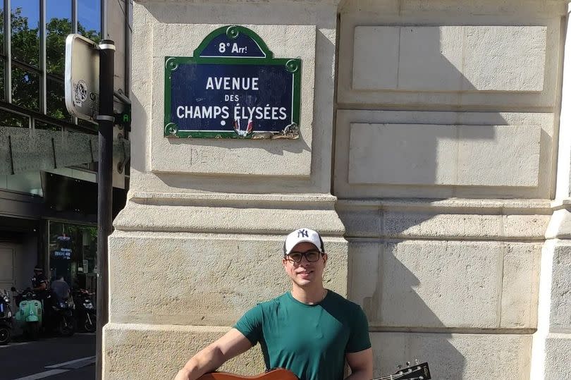 Ayres Sasaki plays guitar outside