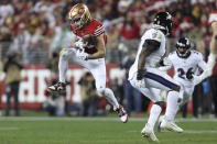 San Francisco 49ers tight end George Kittle, left, catches a pass against the Baltimore Ravens during the second half of an NFL football game in Santa Clara, Calif., Monday, Dec. 25, 2023. (AP Photo/Jed Jacobsohn)