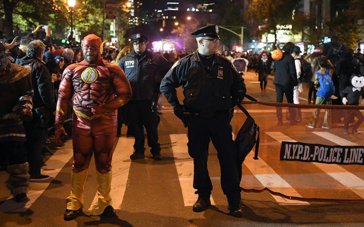 NYPD officers stand guard during the 44rd Annual Halloween Parade in New York  - AFP