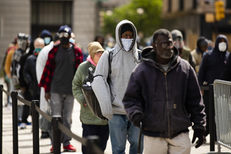 People wait in line to receive food as part of a new initiative called Step Up to the Plate, outside City Hall in Philadelphia, Friday, April 17, 2020. The program aims to help those with food insecurity and is a partnership of Broad Street Ministry, Prevention Point Philadelphia, and Project HOME, with the City of Philadelphia. (AP Photo/Matt Rourke)