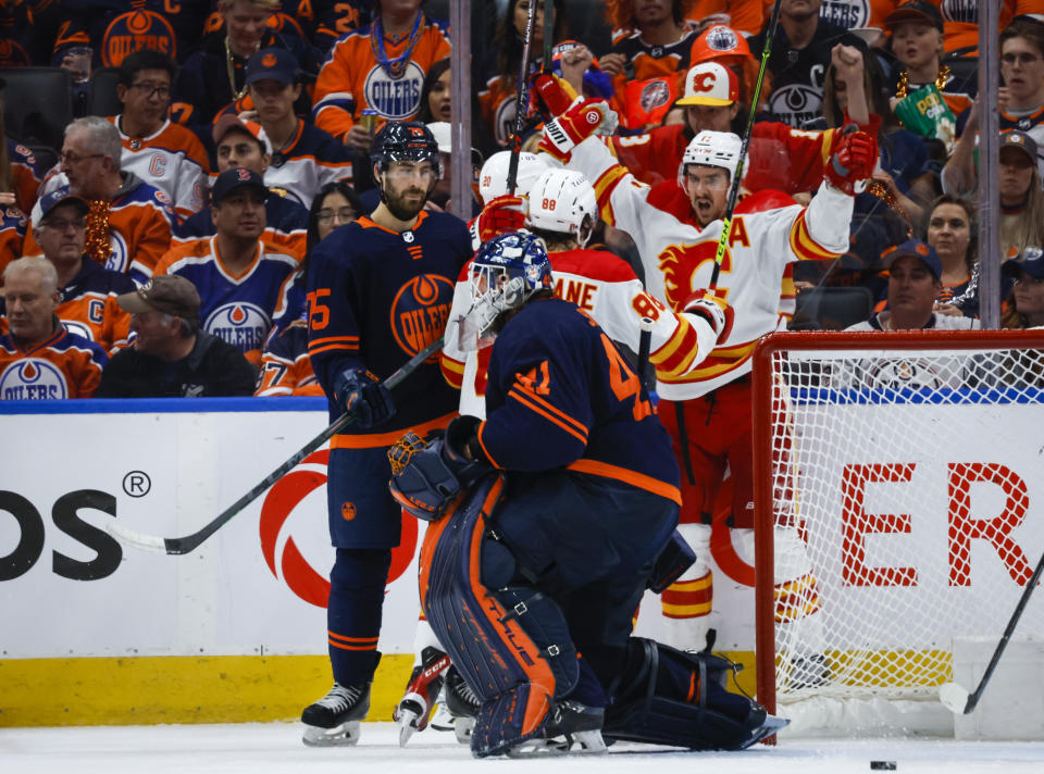 Calgary Flames forward Mikael Backlund, right, celebrates his goal with teammates as Edmonton Oilers goalie Mike Smith gets up from the ice during the second period of Game 4 of an NHL hockey Stanley Cup playoffs second-round series Tuesday, May 24, 2022, in Edmonton, Alberta. (Jeff McIntosh/The Canadian Press via AP)