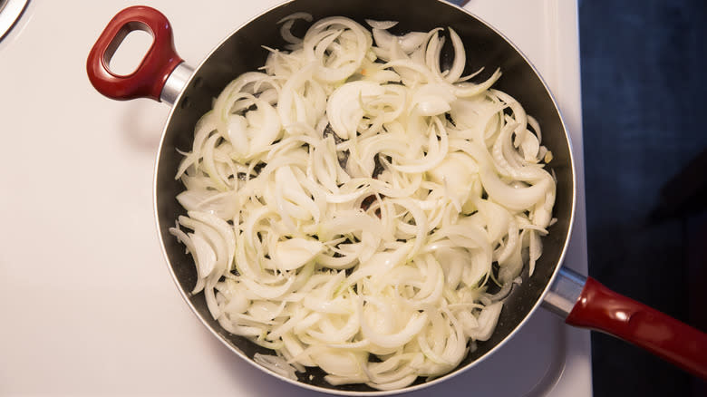 sliced onions cooking in pan 