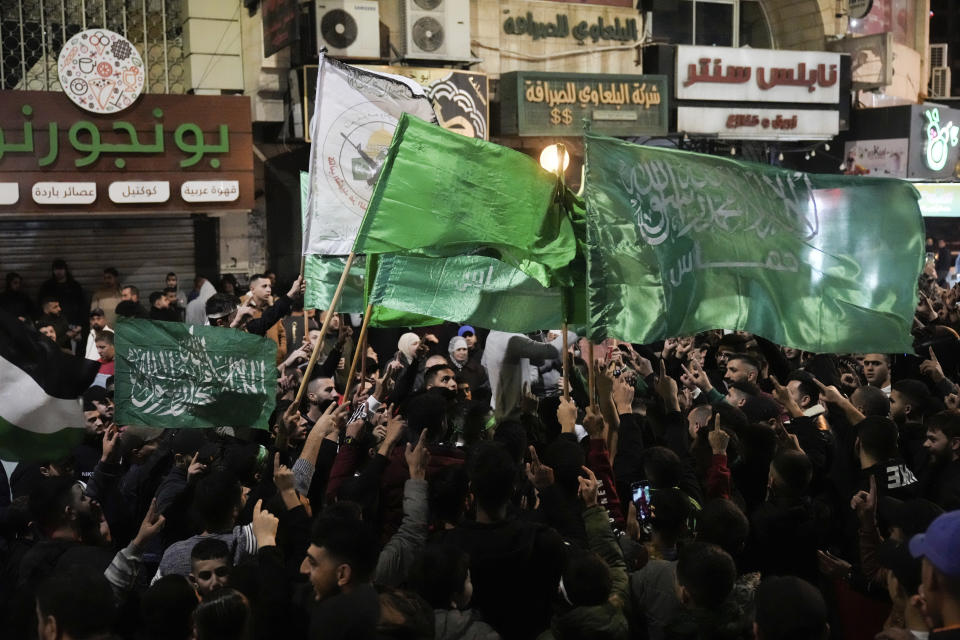 Palestinians wave Hamas flags as they celebrate the Israeli release of Palestinian prisoners in the West Bank city of Nablus, Friday, Nov. 24, 2023. The release came on the first day of a four-day cease-fire deal between Israel and Hamas during which the Gaza militants have pledged to release 50 hostages in exchange for 150 Palestinians imprisoned by Israel. (AP Photo/Majdi Mohammed)