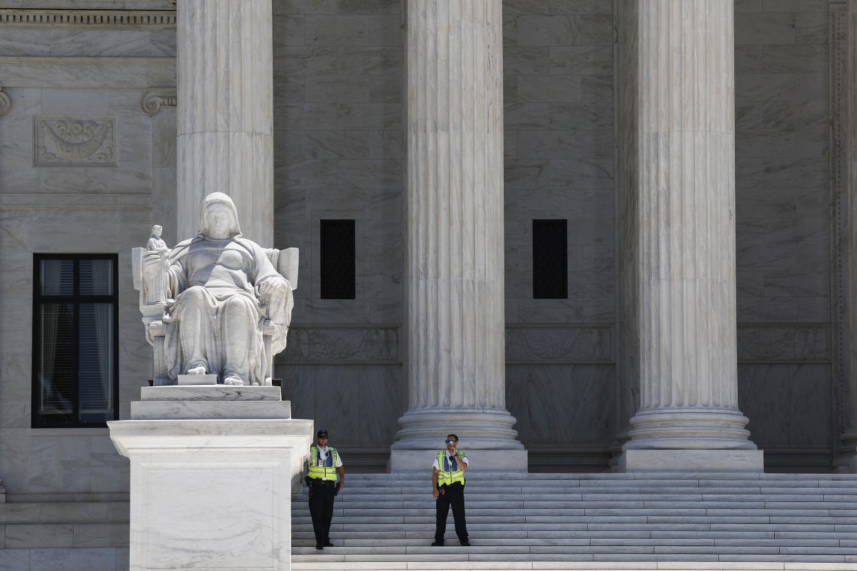 WASHINGTON, DC - JULY 11: Law Enforcement officers stand at the steps of the U.S. Supreme Court on July 11, 2022 in Washington, DC. Activists with NextGen America placed chrysanthemums in front of the U.S. Supreme Court to symbolize the number of people the group believes will die as a result of the Dobbs v. Jackson Women's Health Organization decision. (Photo by Anna Moneymaker/Getty Images)