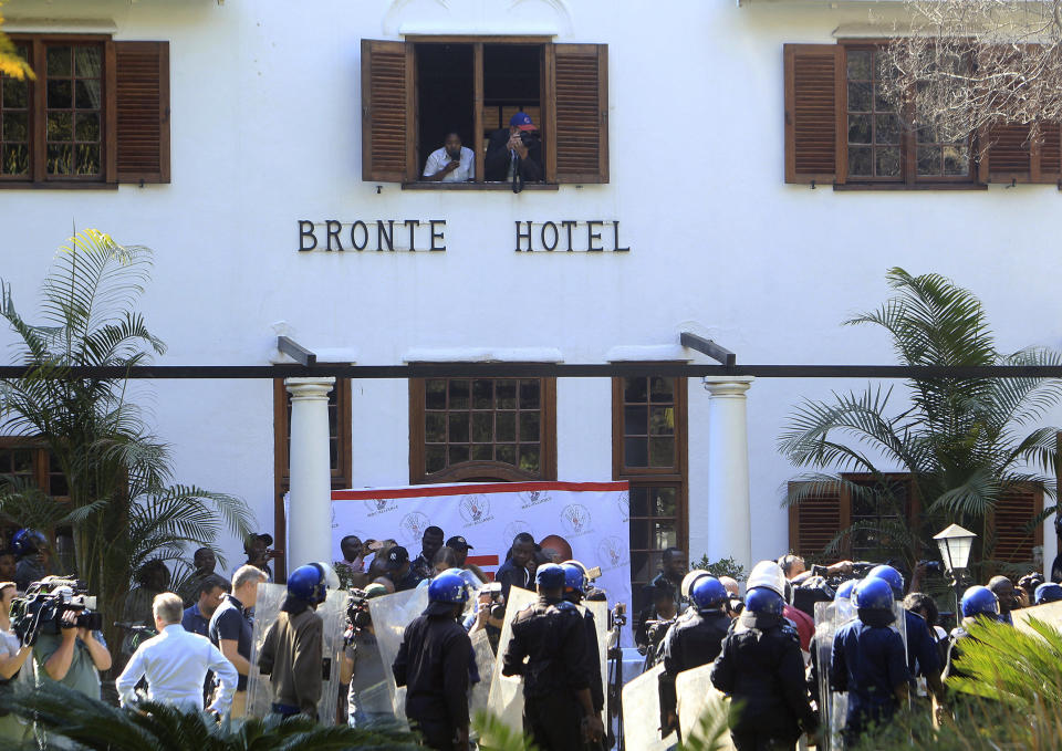 Riot police enter the Bronte hotel, where a press conference by opposition leader Nelson Chamisa was scheduled to take place, in Harare, Zimbabwe, Friday Aug. 3, 2018. Hours after President Emmerson Mnangagwa was declared the winner of a tight election, riot police disrupted a press conference where opposition leader Nelson Chamisa was about to respond to the election results. (AP Photo/Tsvangirayi Mukwazhi)