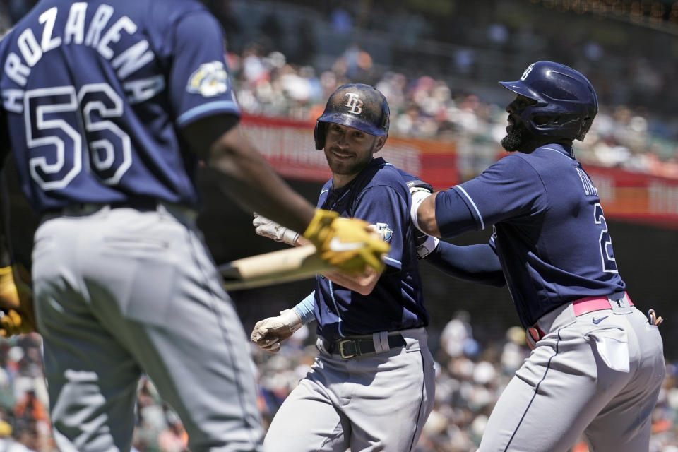 Tampa Bay Rays' Brandon Lowe, center, celebrates with Yandy Díaz, right, after hitting a two-run home run against the San Francisco Giants during the fifth inning of a baseball game Wednesday, Aug. 16, 2023, in San Francisco. (AP Photo/Godofredo A. Vásquez)