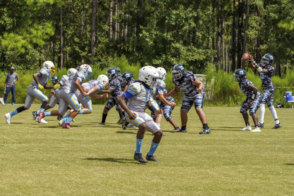 Youth players with the Gulf Coast Sharks Youth Football Club playing a tackle football game on Sept. 10, 2022, in Gautier, Miss. The league's founder, Joel Fields, said youth football leagues are often unregulated. Some leagues allow children as young as five years old to play tackle football, he said. (Joel Fields via AP)