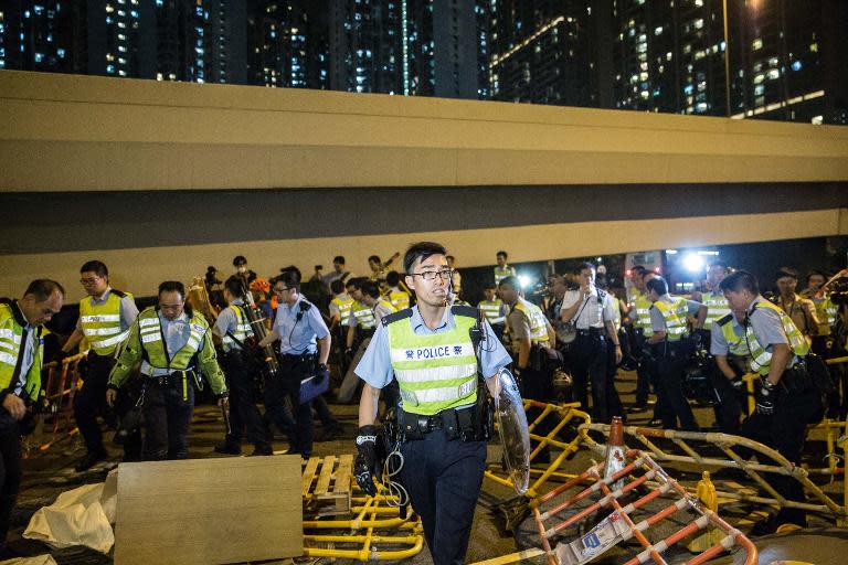 Police clear barriers in a main road after pro-democracy protesters attempted to use them to build a barricade in the Mongkok district of Hong Kong on November 25, 2014