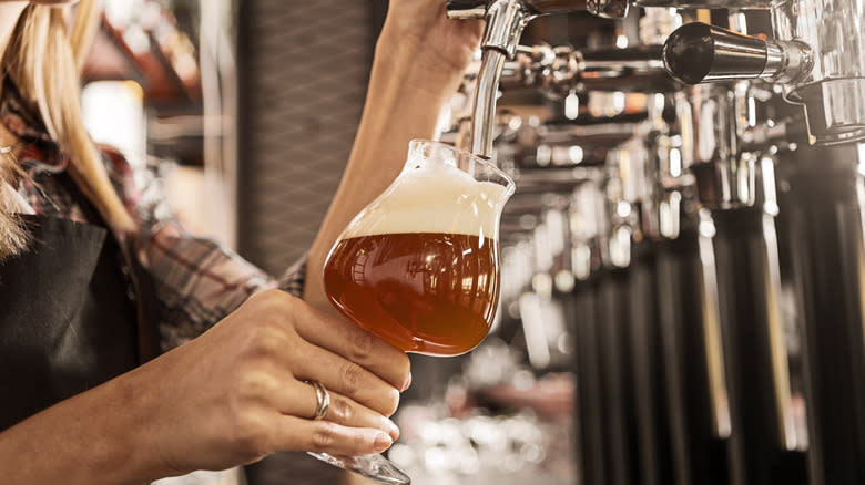 person tapping craft beer in bar