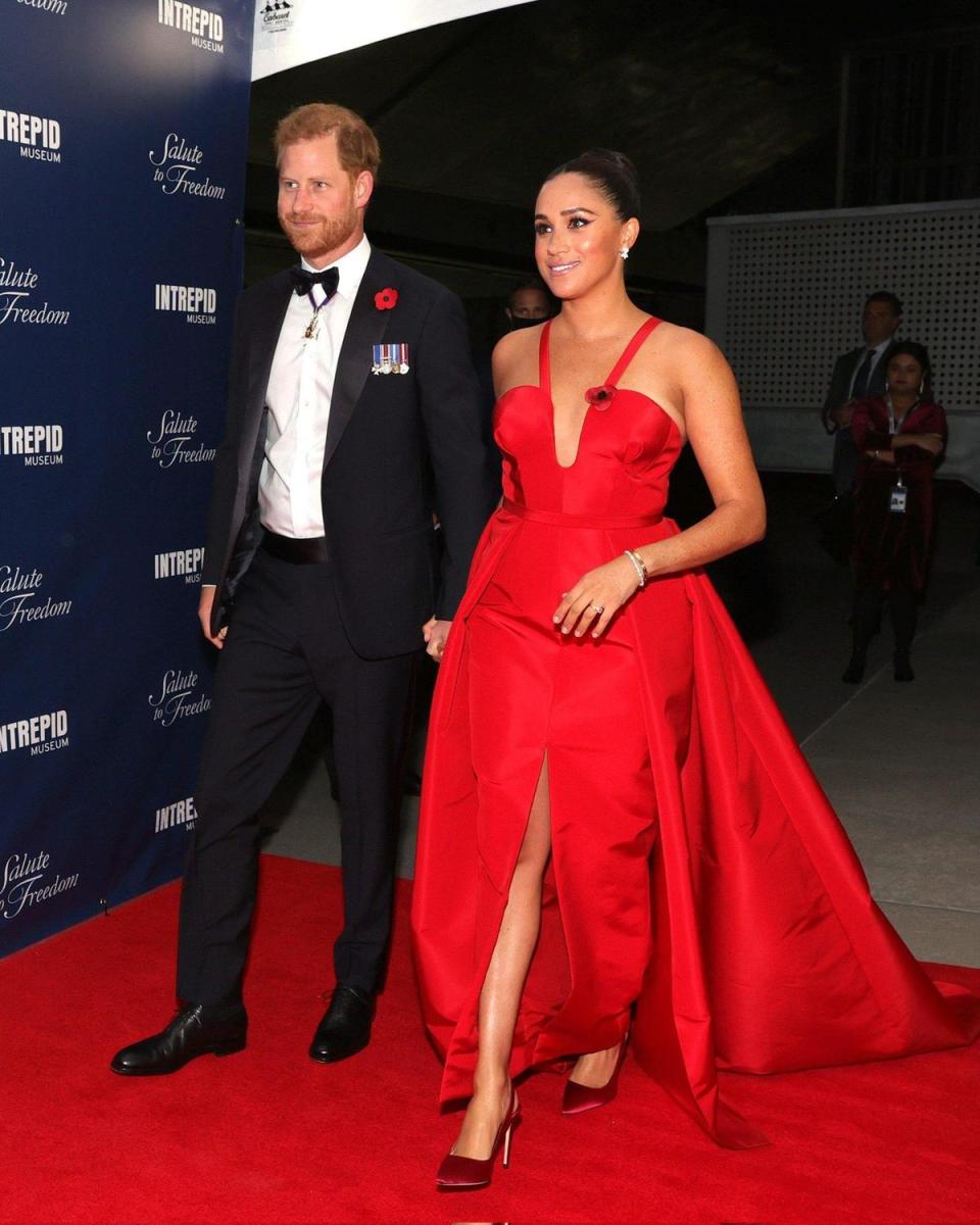 梅根（右）穿一襲Carolina Herrera猩紅色禮服，驚艷全場。（翻攝PHarry_Meghan推特）