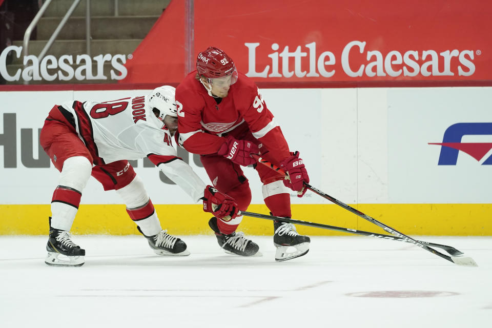 Carolina Hurricanes left wing Jordan Martinook (48) pokes the puck from Detroit Red Wings center Vladislav Namestnikov (92) in the second period of an NHL hockey game Saturday, Jan. 16, 2021, in Detroit. (AP Photo/Paul Sancya)