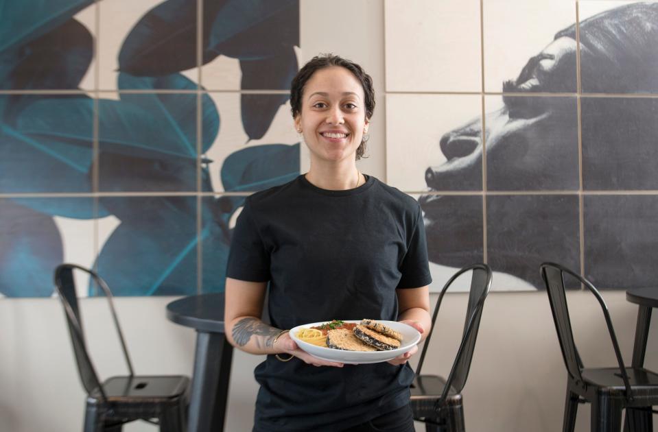LesbiVeggies owner Brennah Lambert holds a plate of eggplant parmesan and spaghetti as she stands in her plant-based and gluten-free Audubon café that is slated to open in February.  