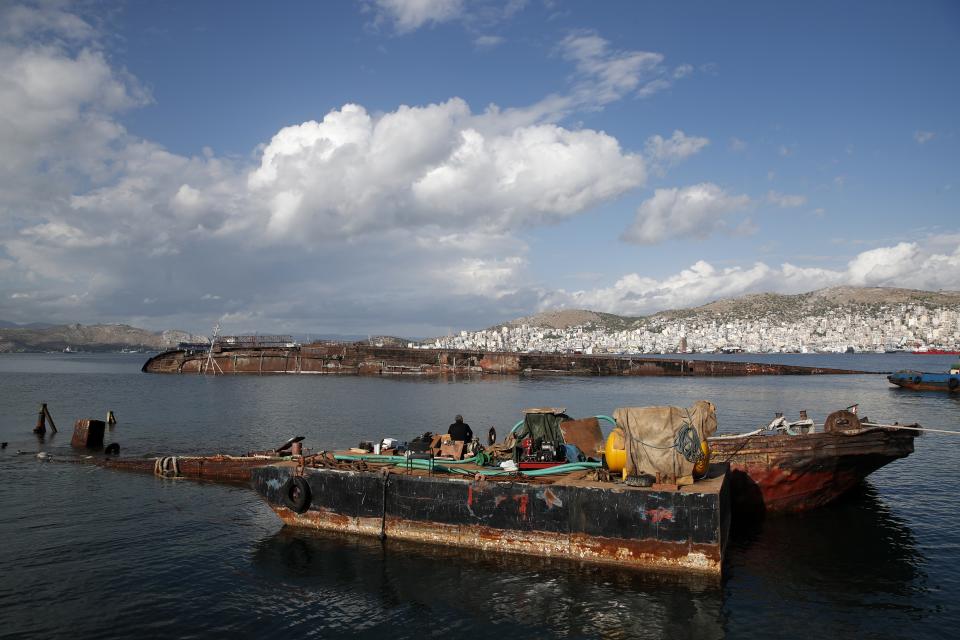 A diver takes a break on a half sunken ship in Damari, an area with eleven shipwrecks, on Salamina island, west of Athens, on Friday, Nov. 8, 2019. Greece this year is commemorating one of the greatest naval battles in ancient history at Salamis, where the invading Persian navy suffered a heavy defeat 2,500 years ago. But before the celebrations can start in earnest, authorities and private donors are leaning into a massive decluttering operation. They are clearing the coastline of dozens of sunken and partially sunken cargo ships, sailboats and other abandoned vessels. (AP Photo/Thanassis Stavrakis)