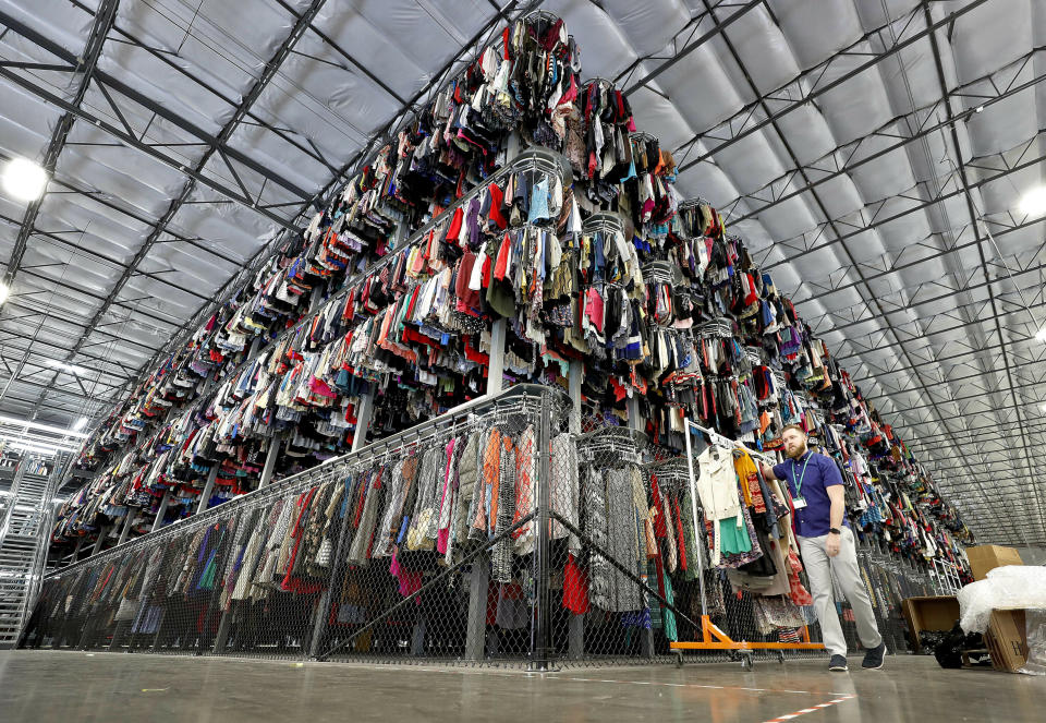 FILE - In this March 12, 2019, file photo thousands of garments are stored on a three-tiered conveyor system at the ThredUp sorting facility in Phoenix. J.C. Penney and Macy’s are in the midst of rolling out a few dozen ThredUp branded shops each in time for the back-to-school shopping season. The partnerships follow a similar deal with department store retailer Stage Stores. (AP Photo/Matt York, File)