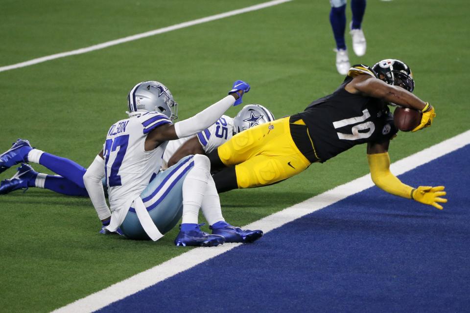 Dallas Cowboys' Donovan Wilson, left front, and Xavier Woods left rear, are unable to stop Pittsburgh Steelers wide receiver JuJu Smith-Schuster (19) from scoring a touchdown after catching a pass in the second half of an NFL football game in Arlington, Texas, Sunday, Nov. 8, 2020. (AP Photo/Michael Ainsworth)