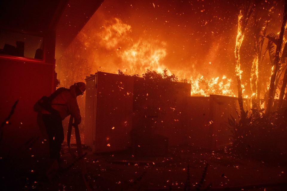 Firefighters try to save a home on Tigertail Road from the Getty fire, Oct. 28, 2019, in Los Angeles, Calif. (Photo: Christian Monterrosa/AP)