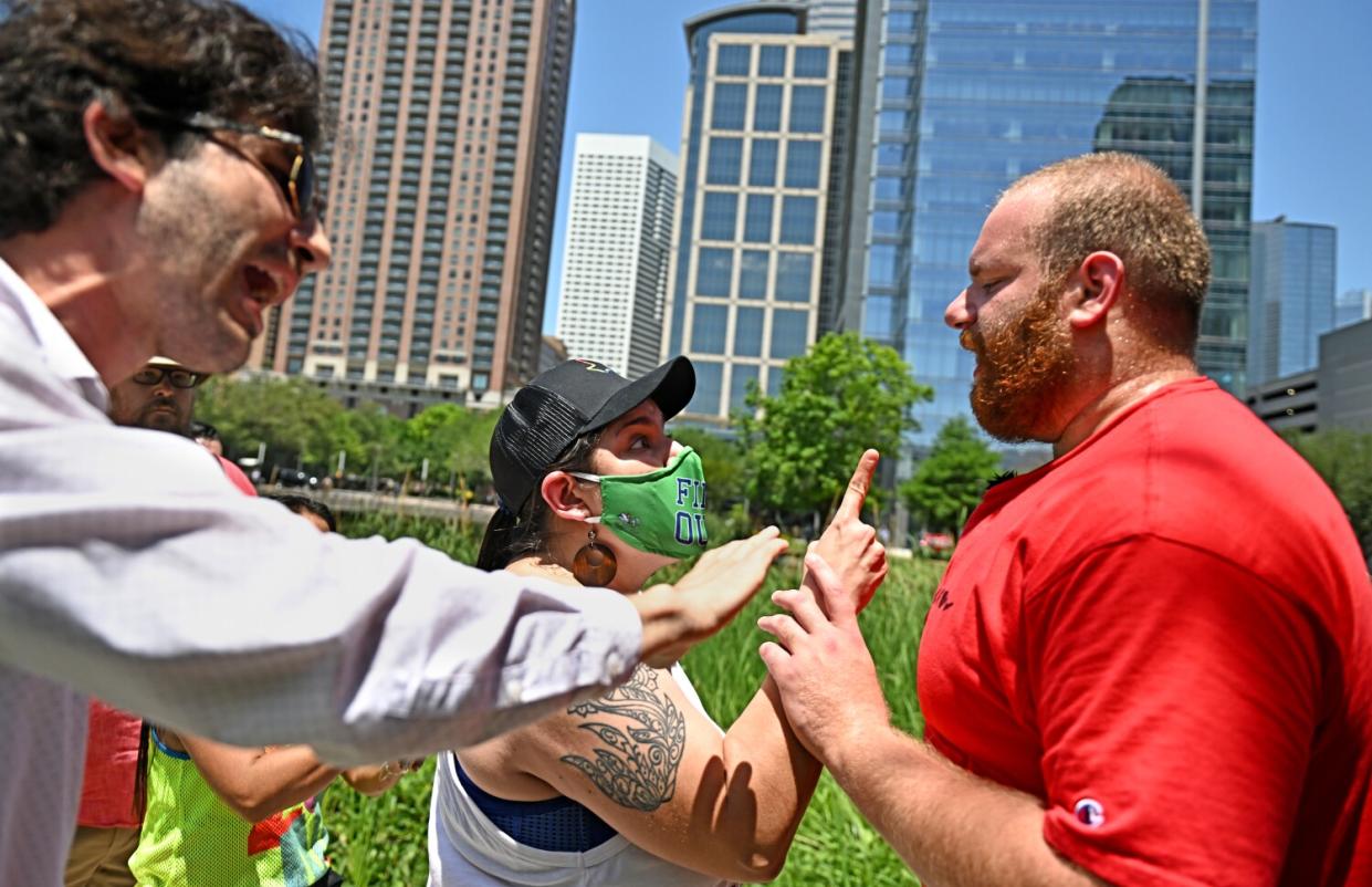 Two protestors gesturing as they argue with an opponent