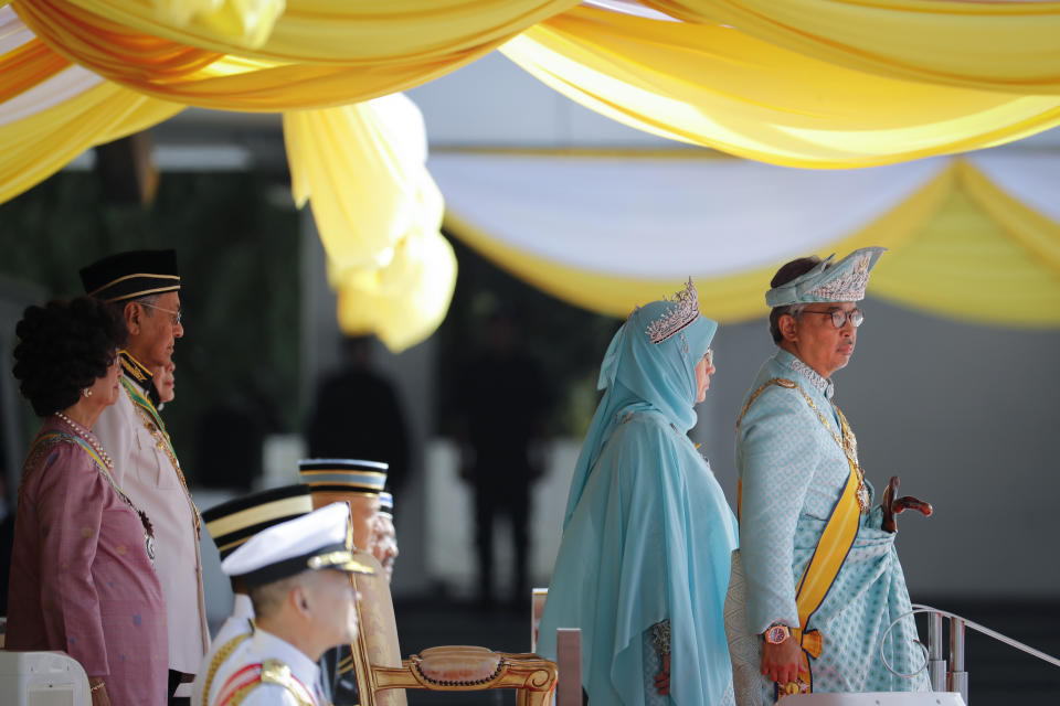Malaysian King Sultan Abdullah Sultan Ahmad Shah, right, stands before inspecting an honor guard during his welcome ceremony at Parliament House in Kuala Lumpur, Malaysia, Thursday, Jan. 31, 2019. Sultan Abdullah, ruler of central Pahang state, was named Malaysia's new king, replacing Sultan Muhammad V who abdicated unexpectedly after just two years on the throne. Second from left is Prime Minister Mahathir Mohamad. (AP Photo/Vincent Thian)