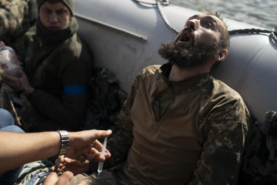 Un soldado ucraniano gesticula mientras recibe una inyección durante una evacuación de soldados lesionados que participan en una contraofensiva, el 25 de septiembre de 2022, cerca del poblado recobrado de Shchurove, Ucrania. (AP Foto/Leo Correa)