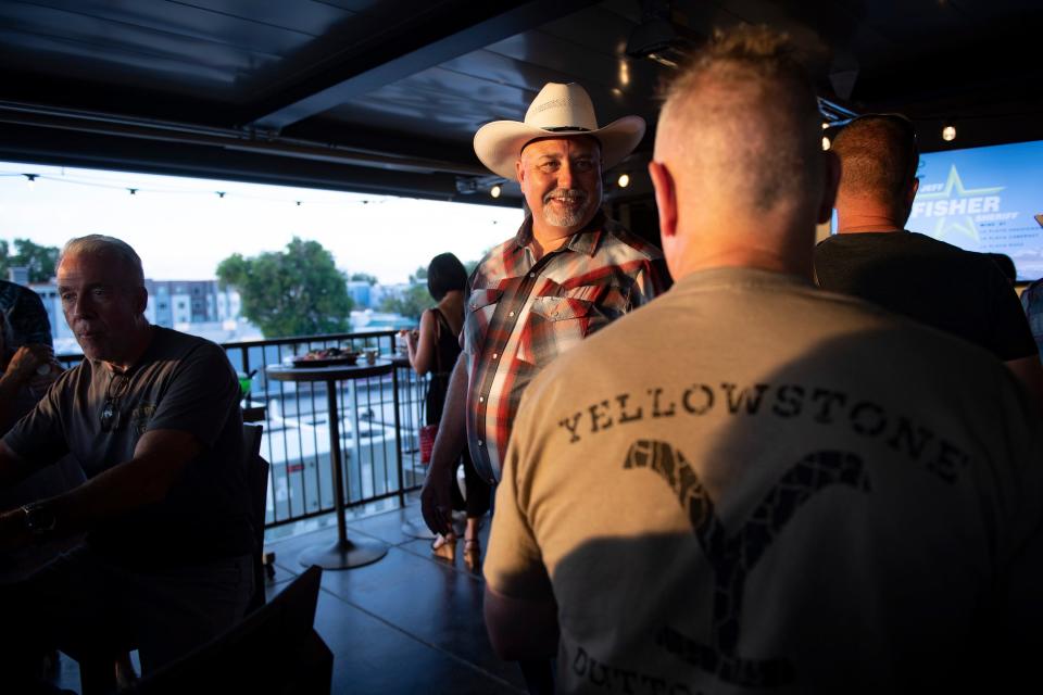 Larimer County sheriff candidate Jeff Fisher talks with his supporters at his primary election party on the rooftop of Desk Chair in Loveland on Tuesday.