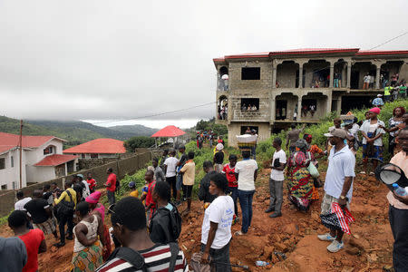 People gather over the hill overlooking the scene of the mudslide in the mountain town of Regent, Sierra Leone August 16, 2017. REUTERS/Afolabi Sotunde