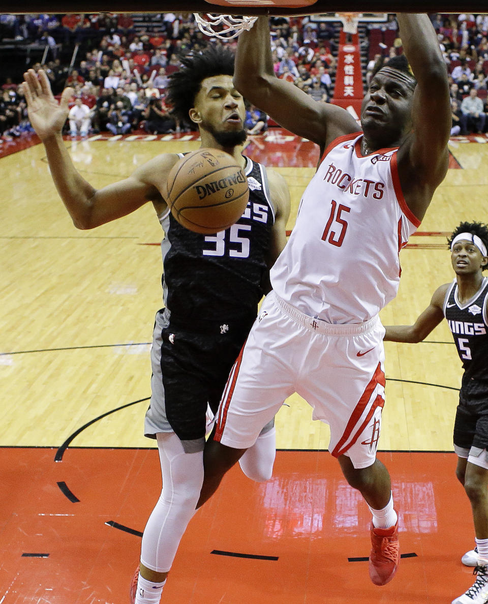 Houston Rockets center Clint Capela (15) dunks as Sacramento Kings forward Marvin Bagley III defends during the first half of an NBA basketball game, Saturday, March 30, 2019, in Houston. (AP Photo/Eric Christian Smith)