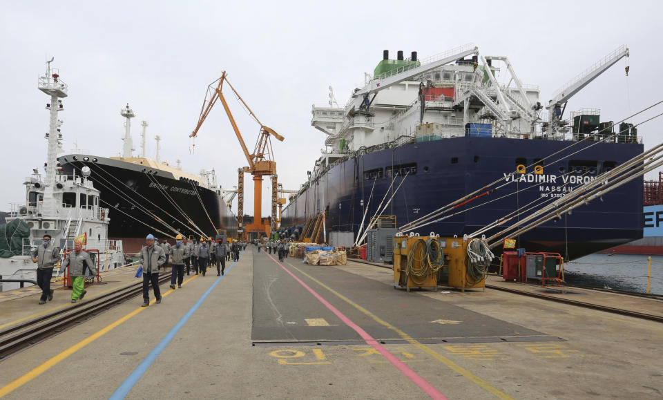 In this Friday, Dec. 7, 2018 photo, workers walk past large-sized liquefied natural gas (LNG) carriers under construction at the Daewoo Shipbuilding and Marine Engineering facility in Geoje Island, South Korea. The boom in U.S. fossil-fuel production has been matched by a rush on the other side of the Pacific to build the tankers needed to help supply the seemingly unquenchable thirst for energy among Asia’s top economies. (AP Photo/Ahn Young-joon)