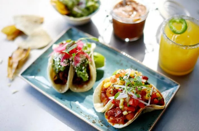 A plate of tacos with a margarita.