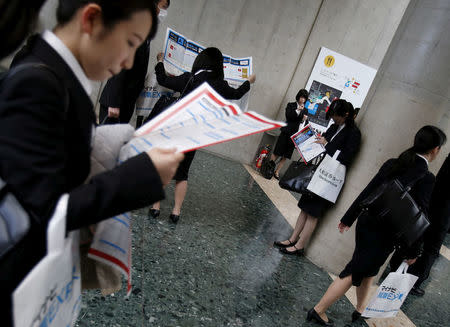 Job seekers look at maps of a job fair held for fresh graduates in Tokyo, Japan, March 20, 2016. REUTERS/Yuya Shino/File Photo