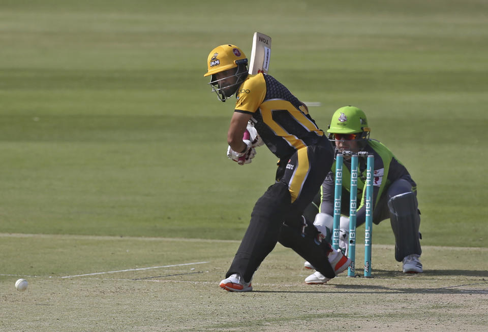 Peshawar Zalmi Ravi Bopara, left, plays a shot while Lahore Qalandars wicketkeeper Ben Dunk watches during a Pakistan Super League T20 cricket match between Peshawar Zalmi and Lahore Qalandars at the National Stadium, in Karachi, Pakistan, Sunday, Feb. 21 2021. (AP Photo/Fareed Khan)