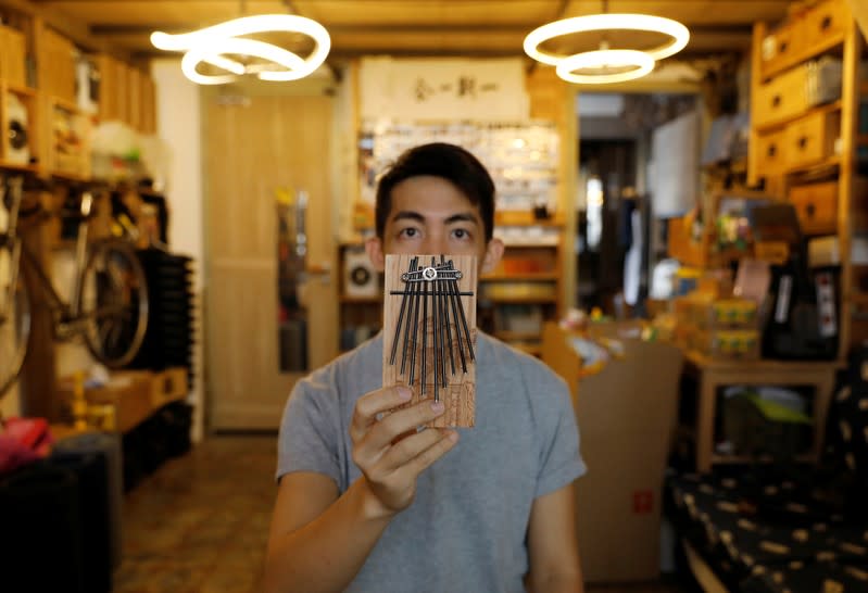 Kevin Cheung, diseñador de productos de reciclaje, sostiene un piano pulgar mientras posa para una foto en su casa en Hong Kong