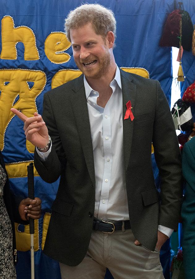 Harry pauses to look at pictures Princess Diana