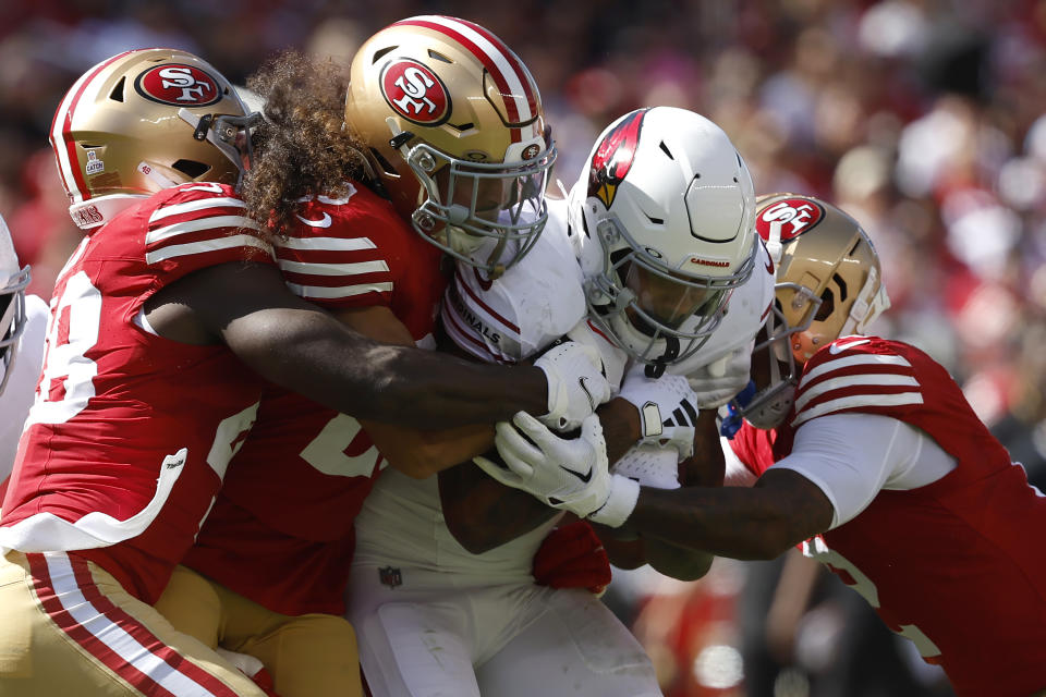 Arizona Cardinals running back James Conner, middle right, is tackled by San Francisco 49ers linebacker Oren Burks, left, safety Talanoa Hufanga, second from left, and cornerback Deommodore Lenoir during the first half of an NFL football game in Santa Clara, Calif., Sunday, Oct. 1, 2023. (AP Photo/Josie Lepe)