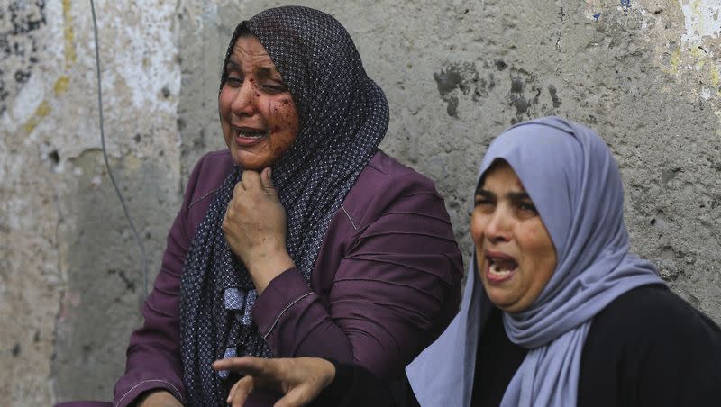 Wounded Palestinian women cry as they sit outside their homes following Israeli airstrikes that targeted their neighbourhood in Gaza City, Monday, Oct. 23, 2023.