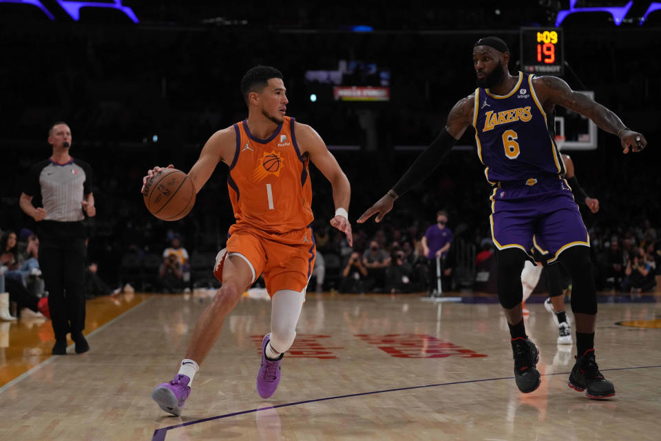 Oct 22, 2021; Los Angeles, California, USA; Phoenix Suns guard Devin Booker (1) is defended by Los Angeles Lakers forward LeBron James (6) in the second half at Staples Center. The Suns defeated the Lakers 115-105. Mandatory Credit: Kirby Lee-USA TODAY Sports