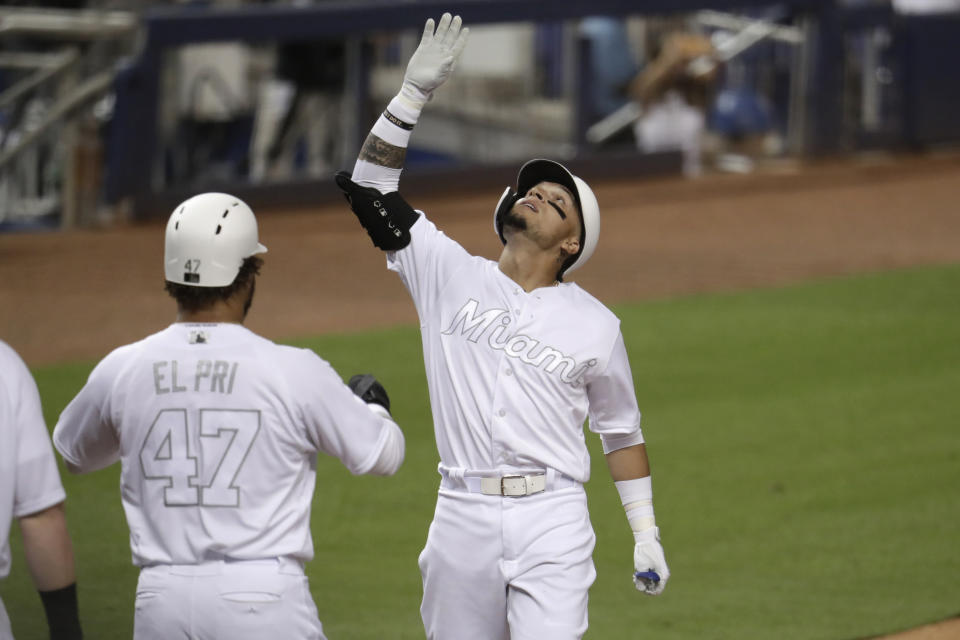 Miami Marlins' Isan Diaz, right, looks up after hitting a three-run home run during the third inning of a baseball game against the Philadelphia Phillies, Friday, Aug. 23, 2019, in Miami. (AP Photo/Lynne Sladky)