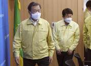 South Korean President Moon Jae-in, left, arrives to preside over a special government meeting to discuss measures to prevent the further spread of COVID-19 at the Daegu City Hall in Daegu, South Korea, Tuesday, Feb. 25, 2020. China and South Korea on Tuesday reported more cases of the new viral illness that has been concentrated in North Asia but is causing global worry as clusters grow in the Middle East and Europe. (Han Sang-kyun/Yonhap via AP)