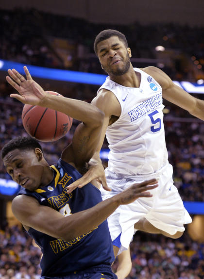 Andrew Harrison (right) and the Wildcats overpowered West Virginia to improve to 37-0. (AP)