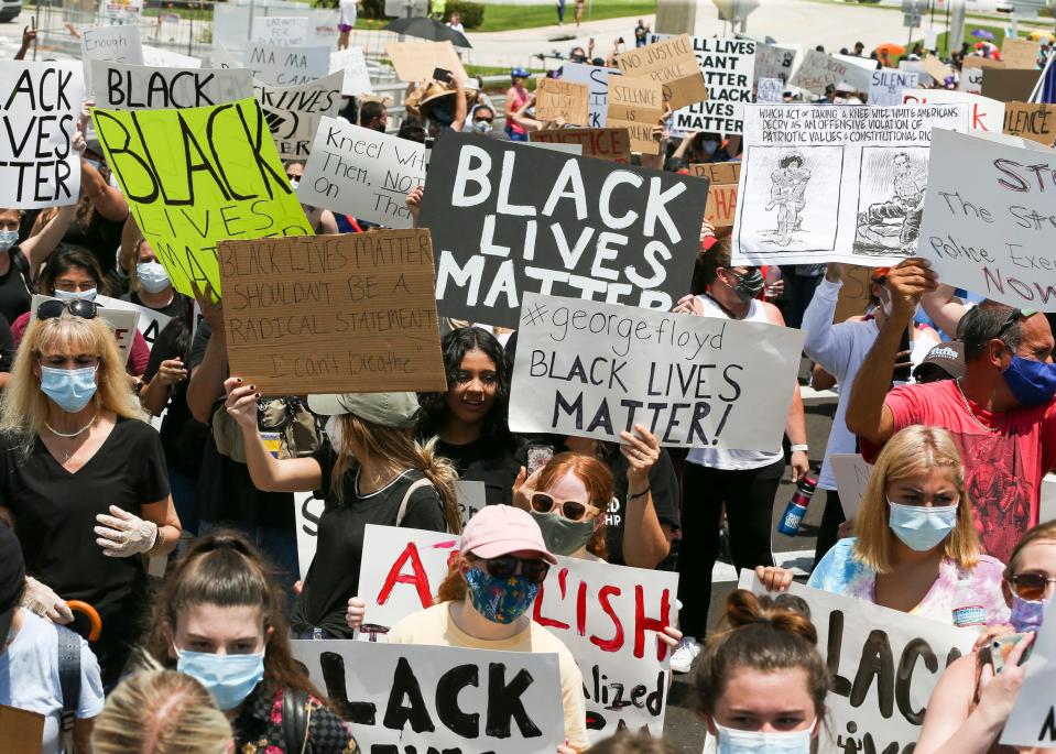 Hundreds of people march on the Roosevelt Bridge in Stuart Sunday, May 31, 2020, as part of a peaceful protest in response to the death of George Floyd while in police custody in Minneapolis, Minn.