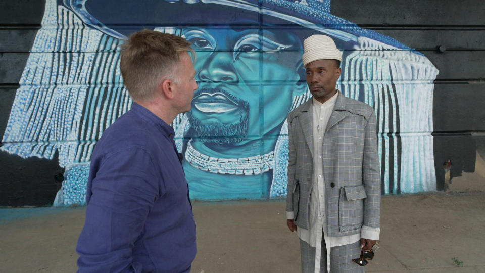 Billy Porter (with correspondent Seth Doane, left) in front of a mural of Porter, painted by artist Camerin 