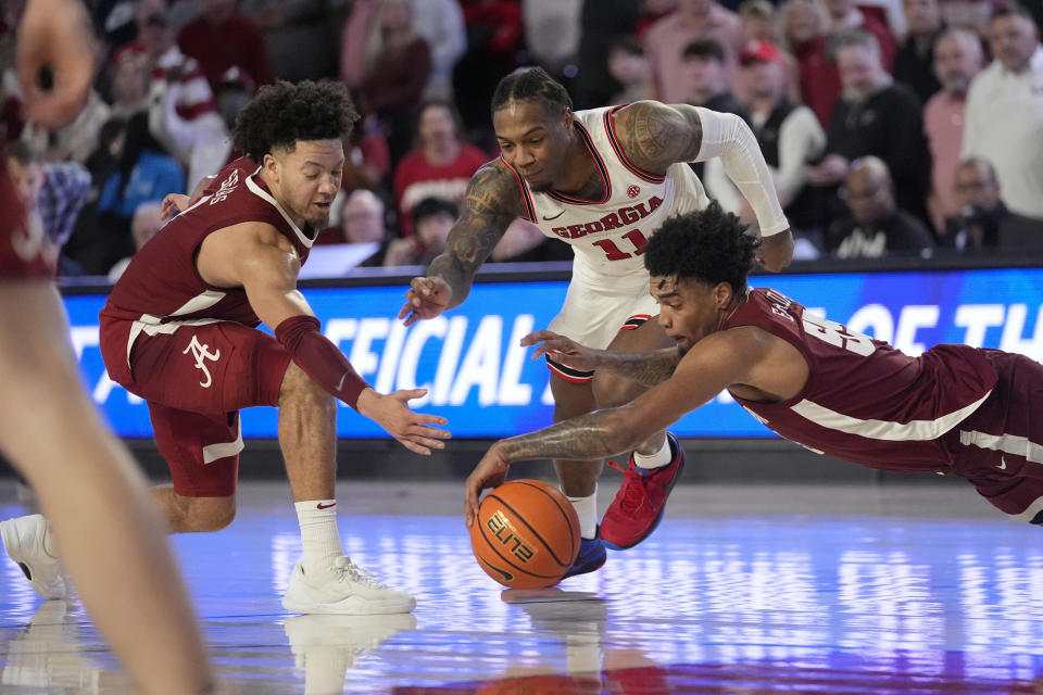 Alabama guards Mark Sears (1), left, and Aaron Estrada (55) battle Georgia guard Justin Hill (11) for a loose ball in the second half of an NCAA college basketball game Wednesday, Jan. 31, 2024, in Athens, Ga. (AP Photo/John Bazemore)