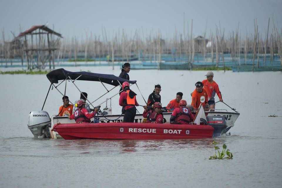 Rescuers search for victims of a capsized ferry in Binangonan, Rizal province, Philippines, Friday, July 28, 2023. The ferry turned upside down when passengers suddenly crowded to one side in panic as fierce winds pummeled the wooden vessel, killing a number of people, officials said Friday. (AP Photo/Aaron Favila)