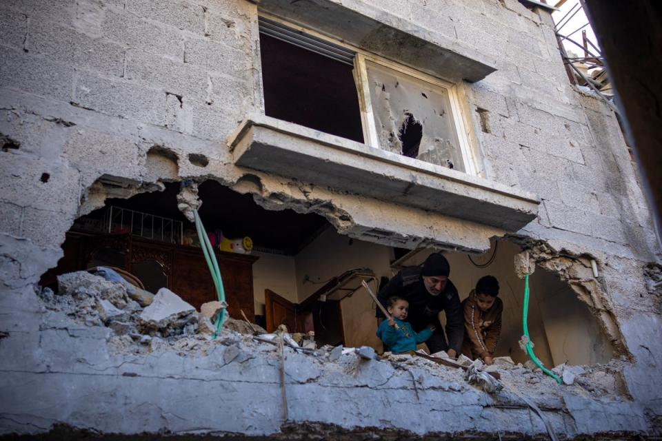 Palestinians look at the destruction after an Israeli strike in Rafah (AP)