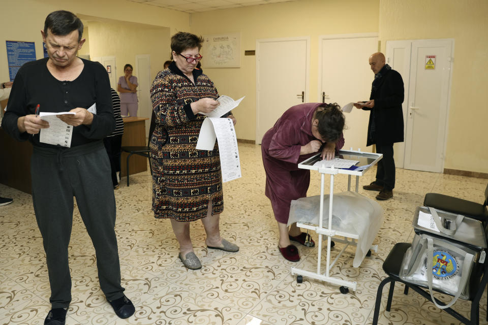 Moldovans look at their ballots before casting their votes, at a hospital, during local elections in Chisinau, Moldova, Sunday, Nov. 5, 2023. Moldovans are casting ballots in nationwide local elections amid claims by Moldovan authorities that Russia has been conducting “hybrid warfare” to undermine the vote in the European Union candidate country. (AP Photo/Aurel Obreja)